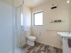 A bathroom with a shower, a toilet, and a sink at The Tranquil Edge - Te Anau Holiday Home, Te Anau