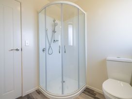 A bathroom with a shower and a toilet at The Tranquil Edge - Te Anau Holiday Home