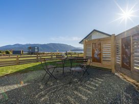 An outdoor seating area with table and chairs at The Tranquil Edge - Te Anau Holiday Home in Te Anau