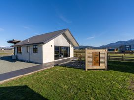 A house with a patio and sign at The Tranquil Edge - Te Anau Holiday Home Te Anau