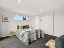 A bedroom with a bed and lamp at Vista Haven - Bannockburn Holiday Home in Bannockburn