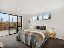 A bedroom with a bed and window at Vista Haven - Bannockburn Holiday Home Bannockburn