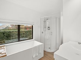 A bathroom with a bathtub and shower at Vista Haven - Bannockburn Holiday Home