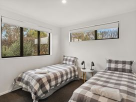 A bedroom with two beds and windows at Vista Haven - Bannockburn Holiday Home, Bannockburn