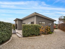 A house with garden and gravel pathway at Vista Haven - Bannockburn Holiday Home Bannockburn