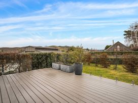 A deck with planters and views of houses and mountains at Vista Haven - Bannockburn