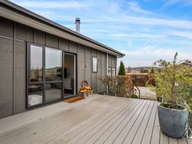 A deck area with a planter and windows at Vista Haven - Bannockburn