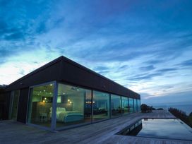 A house with large windows and a pool at The Glass House - Raglan Escape, Raglan