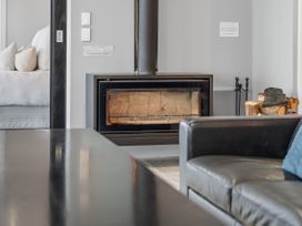 A living room with a fireplace and sofa at The Glasshouse at Block295 Raglan