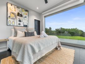 A bedroom with a bed and artwork at The Glasshouse at Block295 Raglan