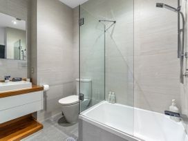A bathroom with a shower, bathtub, sink, and toilet at The Glasshouse at Block295 Raglan
