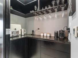 A kitchenette with appliances and glassware at The Glasshouse at Block295 Raglan
