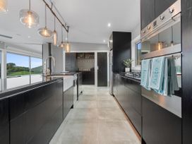 A kitchen with cabinets, sink, and appliances at The Glasshouse at Block295 Raglan