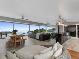 A living room with dining table and kitchen island at The Glasshouse at Block295 Raglan