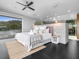 A bedroom with a bed and nightstand at The Glasshouse at Block295 Raglan