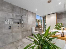 A bathroom with a shower, toilet, and sink at The Glasshouse at Block295 Raglan