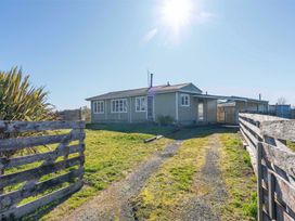 A house with a yard and fence at The Flax Cottage - National Park