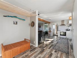 A living room with a bench and kitchen area at The Flax Cottage - National Park Holiday Home