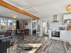 A living room with a dining area and kitchen appliances at The Flax Cottage - National Park