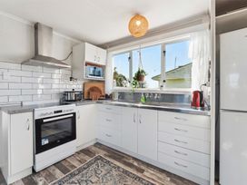 A kitchen with an oven and sink at The Flax Cottage - National Park Holiday Home
