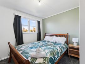 A bedroom with a bed and nightstand at The Flax Cottage - National Park