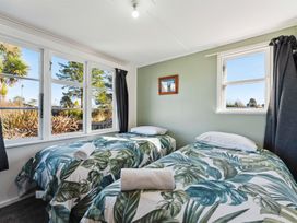 A bedroom with two beds and windows at The Flax Cottage - National Park