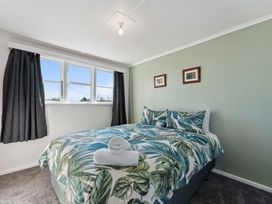 A bedroom with a bed and two pictures on the wall at The Flax Cottage - National Park