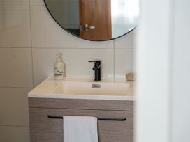 A bathroom sink with a faucet and hand soap at The Flax Cottage - National Park