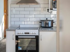 A kitchen with an oven and a slow cooker at The Flax Cottage - National Park Holiday Home
