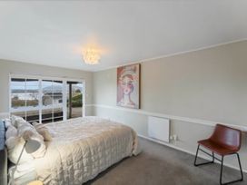 A bedroom with a bed and painting at Acacia Horizons - Taupo Holiday Home Acacia Bay