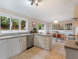 A kitchen with a sink and dining area at Acacia Horizons - Taupo Holiday Home Acacia Bay