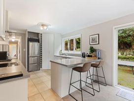 A kitchen with appliances and seating at Acacia Horizons - Taupo Holiday Home Acacia Bay