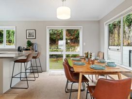 A dining area with a table set for dinner at Acacia Horizons - Taupo Holiday Home, Acacia Bay