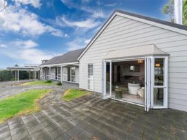 An outdoor view of a house with a patio and sliding doors at Acacia Horizons - Taupo Holiday Home, Acacia Bay