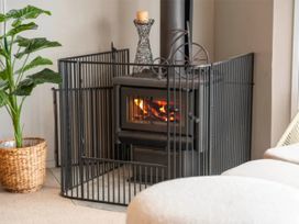 A fireplace with a screen and plant in a living room at Acacia Horizons - Taupo Holiday Home Acacia Bay