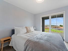 A bedroom with a bed and nightstand at Acacia Horizons - Taupo Holiday Home Acacia Bay