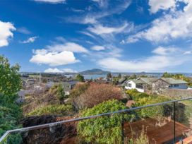 A view of houses and water with mountains in the background at Acacia Horizons - Taupo Holiday Home Acacia Bay