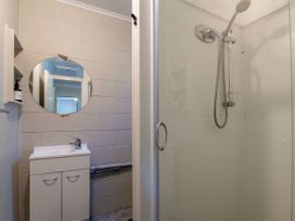 A bathroom with a shower and sink at Rotorua Holiday Home in Rotorua