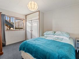 A bedroom with a bed and window at Rotorua Holiday Home in Rotorua