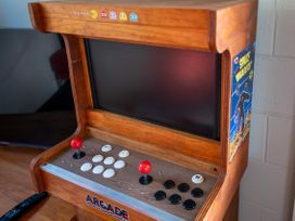 An arcade machine with joystick and buttons in a game room at Rotorua Holiday Home in Rotorua