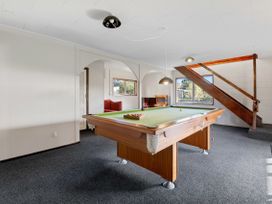 A game room with a pool table and stairs at Rotorua Holiday Home in Rotorua