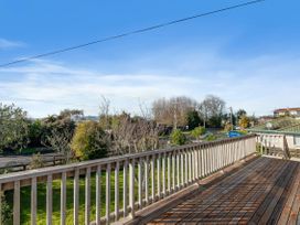 A deck overlooking a garden and street at Rotorua Holiday Home in Rotorua
