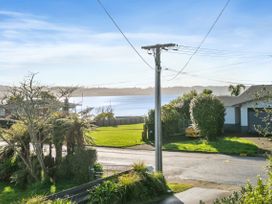 A view of a lake with trees and grass at Rotorua Holiday Home in Rotorua