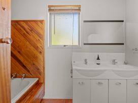 A bathroom with a sink and bath tub at Rotorua Holiday Home in Rotorua