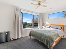 A bedroom with a bed and a window at Rotorua Holiday Home in Rotorua