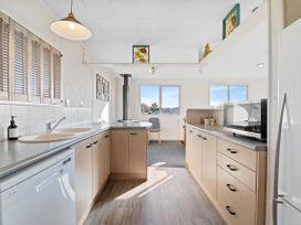 A kitchen featuring cabinets, sink, and a microwave at Rotorua Holiday Home in Rotorua