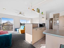 A living room with kitchen counter and sofa at Rotorua Holiday Home in Rotorua