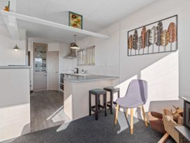 A kitchen with a stove and stools at Rotorua Holiday Home in Rotorua