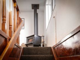A hallway with a stove near the stairs at Rotorua Holiday Home in Rotorua