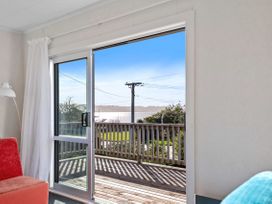 A living room with a sliding door to a deck at Rotorua Holiday Home in Rotorua